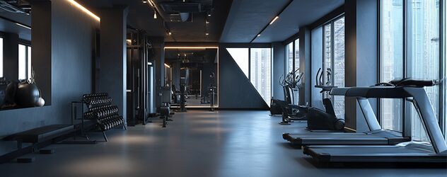 Frontalperspektive auf ein modernes Fitnessstudio mit Fitnessgeräten, Fenster und Gewichten